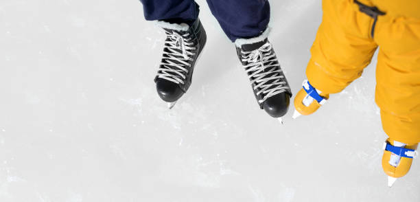 los zapatos de patinaje de padre e hija se acercan al fondo de una pista de hielo. - ice skating ice hockey child family fotografías e imágenes de stock