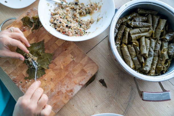 close up photo of human hands preparing dolmades - dolmades imagens e fotografias de stock