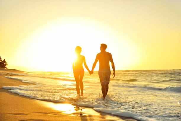 couple romantique en lune de miel amoureux au coucher du soleil sur la plage - swimming trunks swimwear summer bikini photos et images de collection