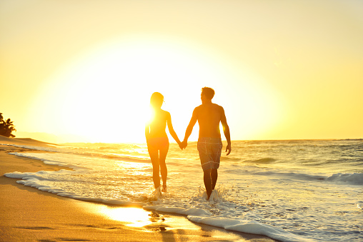 Romantic honeymoon couple in love at beach sunset