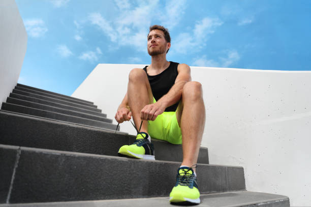 Runner man getting ready to train outdoor on city stairs gym outside tying running shoes laces training cardio workout exercise on staircase. Acitve healthy lifestyle sport athlete fitness motivation Runner man getting ready to train outdoor on city stairs gym outside tying running shoes laces training cardio workout exercise on staircase. Acitve healthy lifestyle sport athlete fitness motivation. lace up stock pictures, royalty-free photos & images