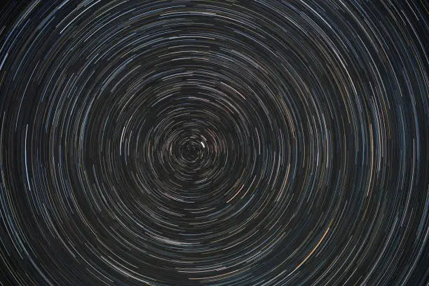 Movement of stars around pole star on north hemisphere. Startrails on night sky, long exposure composition.