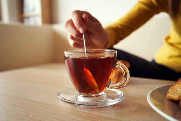 A cup of tea on a table at home A cup of tea on a table in a living room stirring stock pictures, royalty-free photos & images