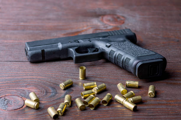 pistola en una mesa de madera - arma de mano fotografías e imágenes de stock