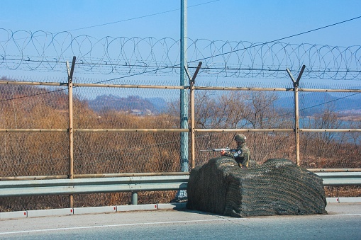 DMZ security. Armed gunner in camouflage uniform and helmet carrying out military service on most dangerous borderline in the world, at the Korean Demilitarized Zone (DMZ). Paju,South Korea ,March 2013