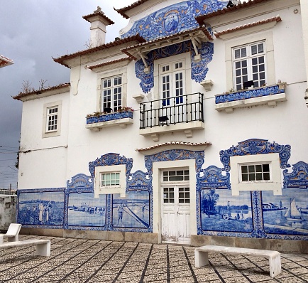 Low angle street view of the old train station of Aveiro covered in decorative blue tiles, Aveiro, Portugal. June 11, 2015.