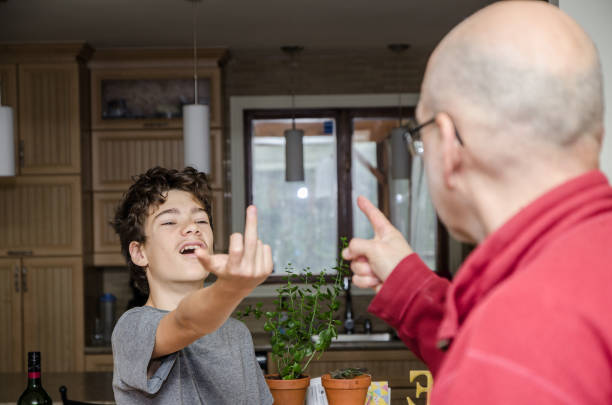 adolescent montrant fuck you doigt à son père - conflict face to face child arguing photos et images de collection