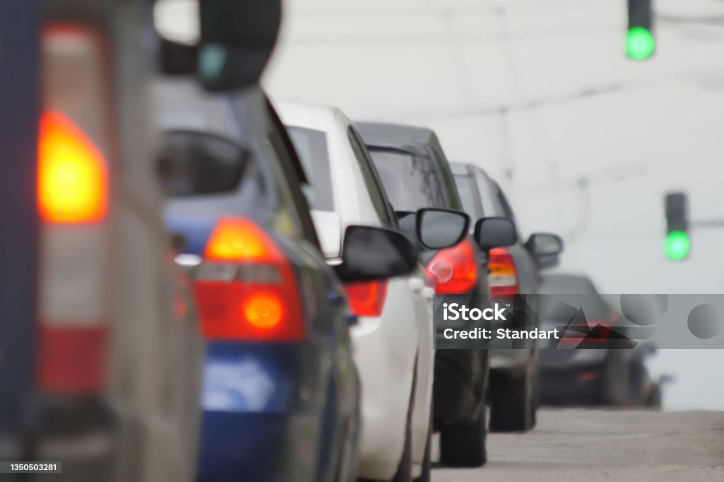 Blurred road car congestion traffic background city defocus. Rush hour traffic jam. Blur background road city congestion in rush hour car traffic day. Crowded cars moving slowly on road busy city blur Blur background road city congestion in rush hour car traffic day. Blurred road car congestion traffic background city defocus. Rush hour traffic jam. Crowded cars moving slowly on road busy city blur Stoplight Stock Photo