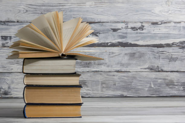 istock Open book, hardback books on wooden table. Back to school. Copy space. 1350503533