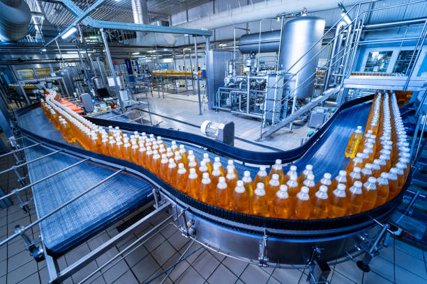 bande transporteuse avec bouteilles de jus ou d’eau dans une usine de boissons moderne - bottling plant brewery industry food photos et images de collection