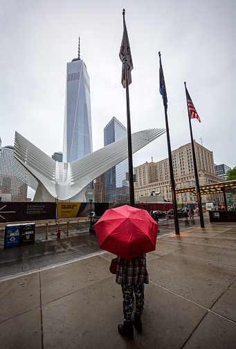 New York, NY, USA - May 22, 2016:  A Rainy day in New York. One man holding an umbrella standing against The Freedom Tower on the background. Lower Manhattan, NY