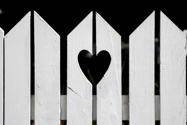 forma del cuore ritagliata dalla recinzione residenziale suburbana bianca - vicino di casa foto e immagini stock