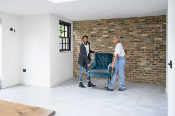 istock Black couple lifting armchair into position on moving day 1350512552