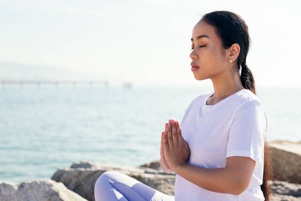 istock young asian woman meditating outdoors in calm 1350513703