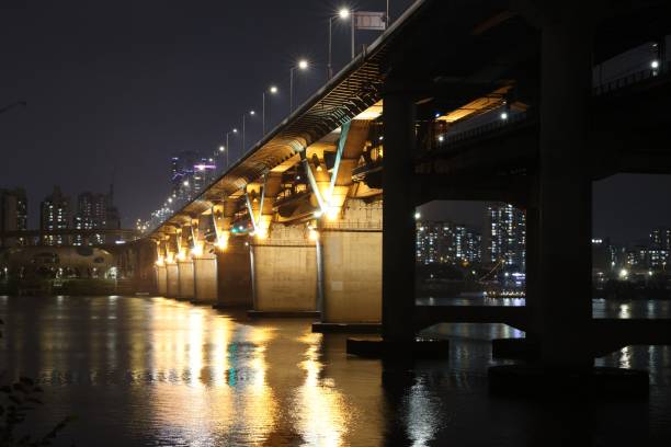 istock night view of bridge over river in yellow light 1350514199