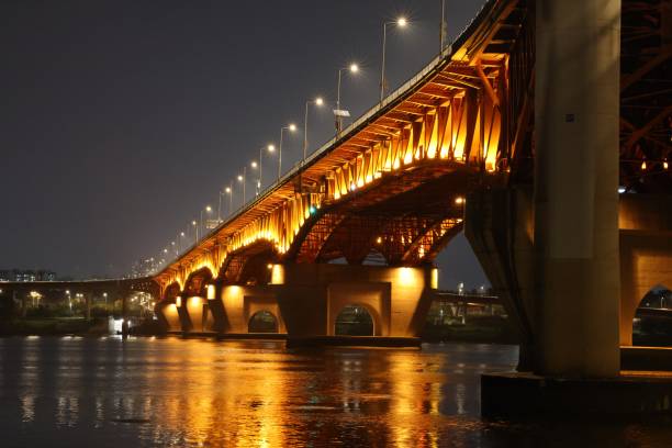 istock Night view of the bridge crossing the river 1350514200