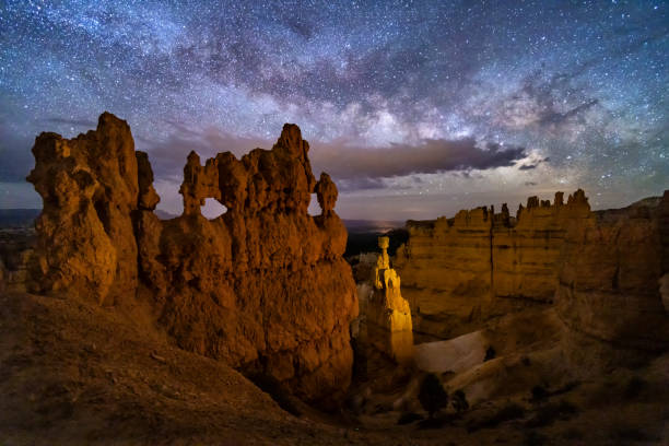 Windows on the Night Sky A hoodoo with small windows and Thor's Hammer against a night sky with clouds and the Milky Way below Sunset Point in ryce Canyon National Park, Utah. bryce canyon stock pictures, royalty-free photos & images