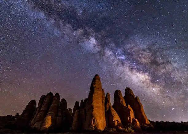 A cluster of sandstone fins in Arches National Park below the heart of the Milky Way in Arches National Park, Utah