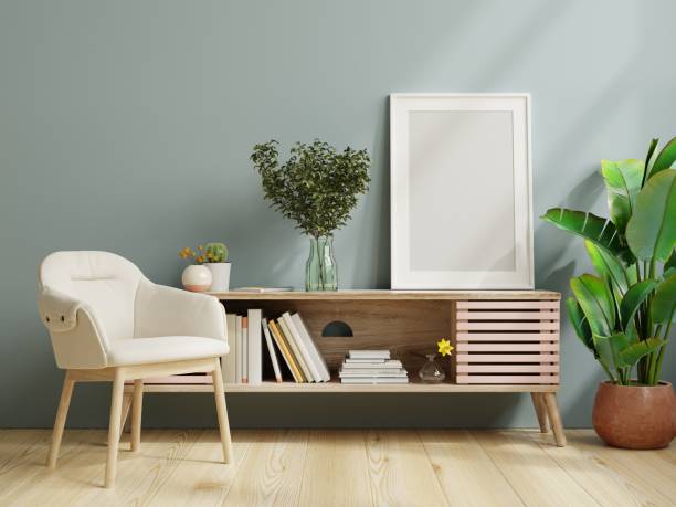 istock Poster mockup with vertical frame on empty dark blue wall in living room interior. 1350524781
