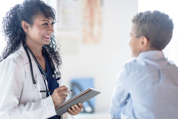 istock Doctor Giving a Young Boy a Check-Up 1350529975