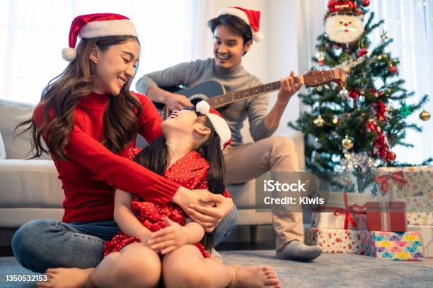 Asian Lovely Family Member Enjoy Sing Christmas Song Together At Home Young Little Daughter Feeling Happy And Excited To Celebrate Holiday Christmas Thankgiving Party Together With Parents In House Stock Photo - Download Image Now