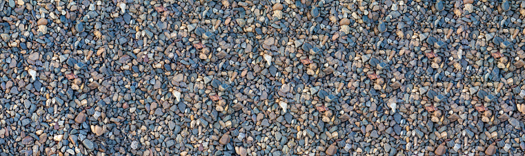 Crushed stone on the seashore. Selective focus on object. The stones were laid on the ground in the garden as a background. Background blur. Pebble stones background. banner