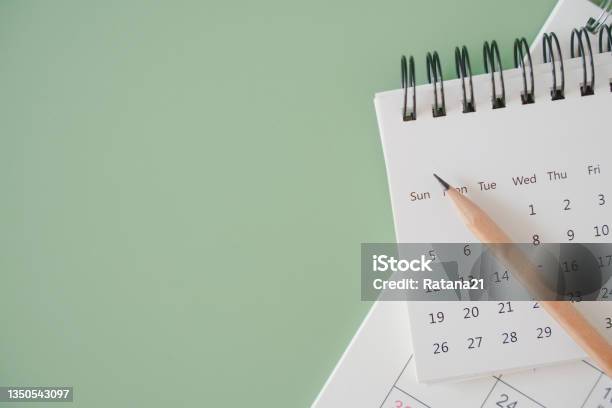 Top View Of White Calendar And Sharpen Brown Pencil On Green Background Schedule Timeline Planning Concept Stock Photo - Download Image Now