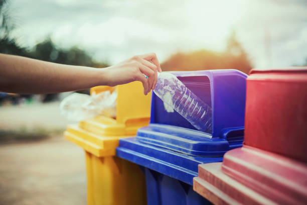 istock hand holding bottle plastic garbage into trash in park 1350544142