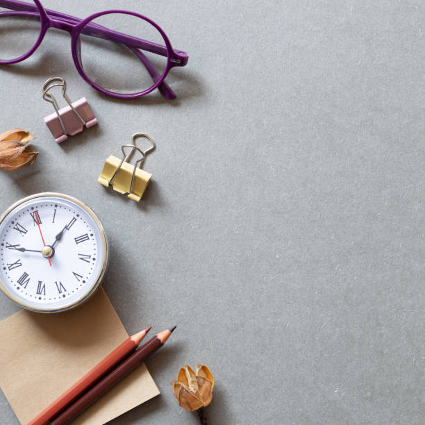 istock Memo pad, pencil, clock, clip, glasses on gray background. workspace. flat lay, top view, copy space 1350549961