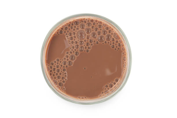 istock Chocolate milk puddle in glass isolated on white background. 1350551155