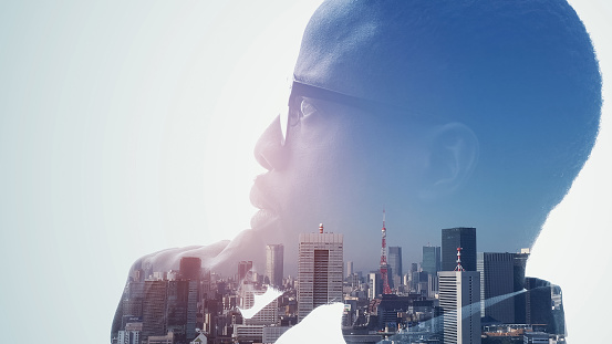 Silhouette of thinking man and modern cityscape. Double exposure.