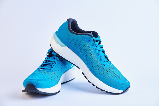 Blue running sneakers on white. Pair of sport male shoes for fitness on white background
