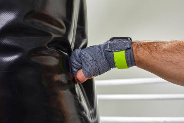 istock Young boxer training his skills hitting a punching bag 1350560808