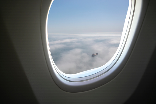 Airplane above cargo ship.