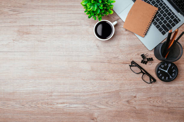 istock Work from home. desk office with laptop, blank notepad, coffee cup and pen on wood table. Flat lay top view copy spce. 1350567177