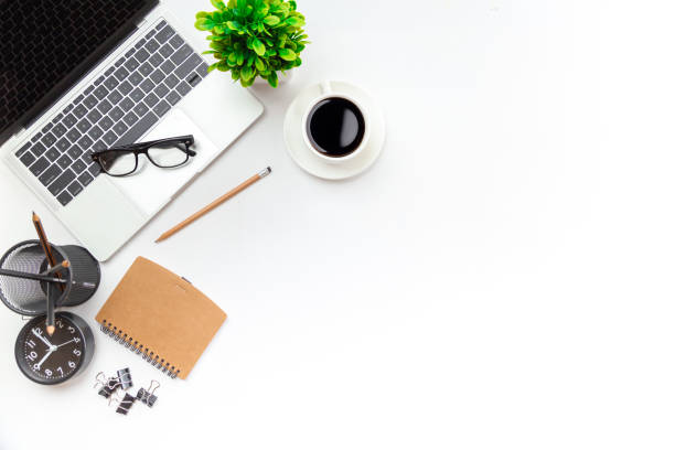 istock White office desk table with blank notebook, computer keyboard and other office supplies. Top view with copy space, flat lay. 1350567188