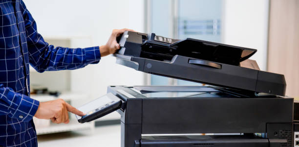 istock Businessmen press button on the panel for using photocopier or printer for printout and scanning document paper at office. 1350567192