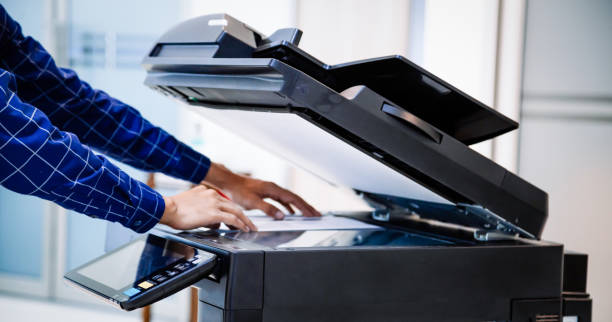 istock Businessmen press button on the panel for using photocopier or printer for printout and scanning document paper at office. 1350567203