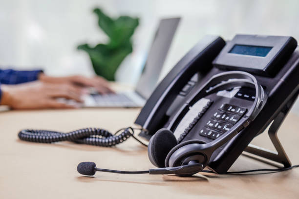 istock Communication support, call center and customer service help desk. telephone devices with VOIP headset in office.Customer service support (call center) concept. 1350567224