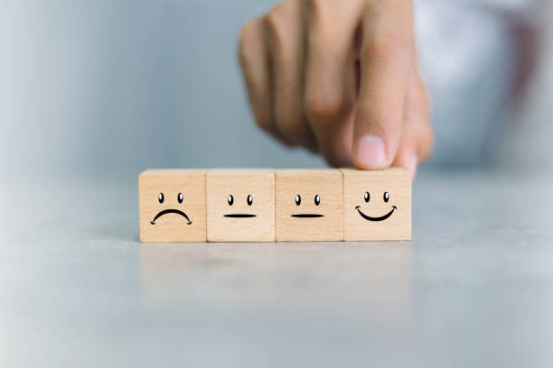 istock Close up customer hand choose smiley face icon on wood cube, Service rating, satisfaction concept. 1350567769