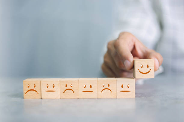 istock Close up customer hand choose smiley face icon on wood cube, Service rating, satisfaction concept. 1350567778