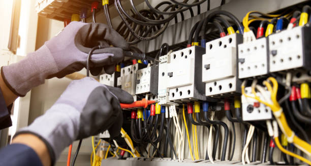 istock Electrician engineer tests electrical installations and wires on relay protection system. Adjustment of scheme of automation and control of electrical equipment. 1350568378