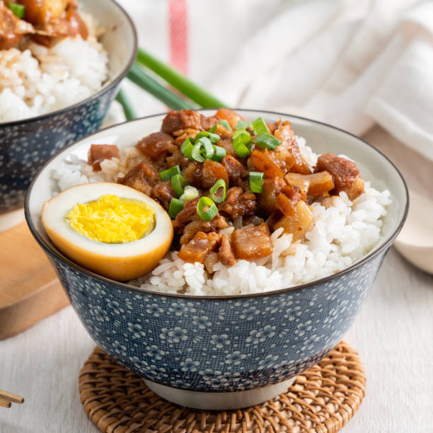 Braised meat over cooked rice, famous and delicious street food in Taiwan. Braised meat rice, close up of stewed pork over cooked rice in Taiwan. Taiwanese famous traditional street food delicacy. braised stock pictures, royalty-free photos & images