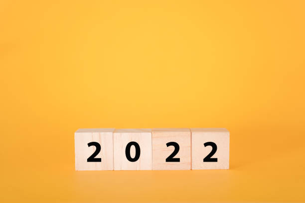 istock Wooden cubes on a yellow background and 2022. 1350572670