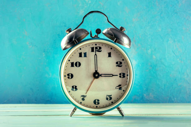 istock A vintage alarm clock on a vibrant blue background 1350572747
