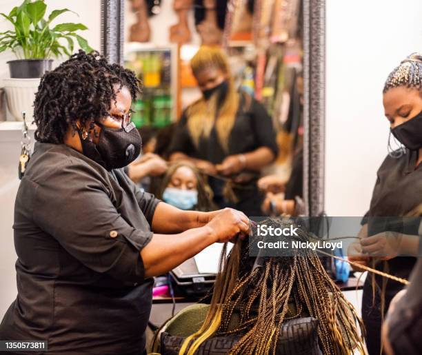 Hairstylists Braiding And Extending A Clients Hair In Salon Stock Photo - Download Image Now