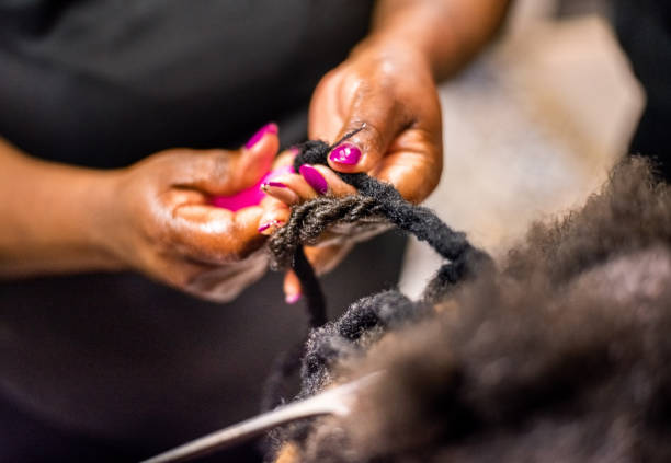 Hairstylist braiding and extending customer's hair Close-up of a hairstylist hands using tools while braiding and extending customer's hair in her beauty salon braided hair stock pictures, royalty-free photos & images