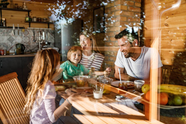 istock Young happy family talking during breakfast at dining table. 1350575043