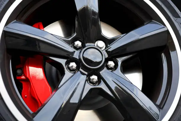 Photo of Modern black painted aluminum rim with red brake caliper
