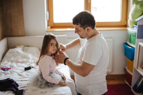 istock Father combing little daughter's hair 1350579586